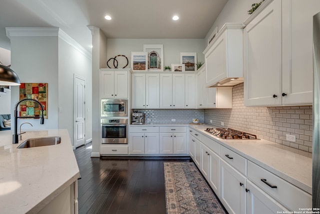 kitchen featuring appliances with stainless steel finishes, dark hardwood / wood-style floors, white cabinetry, and sink