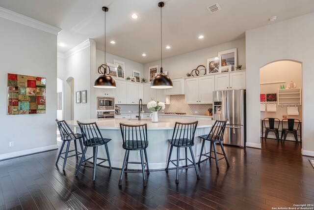 kitchen with pendant lighting, dark wood-type flooring, and appliances with stainless steel finishes