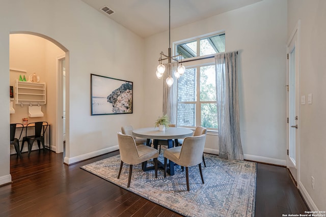 dining room with dark wood-type flooring and a notable chandelier