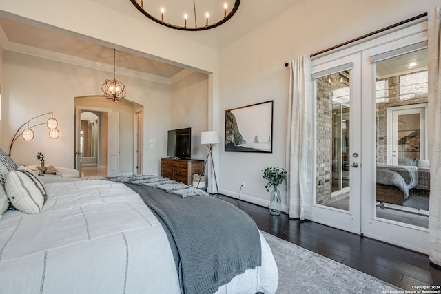 bedroom with french doors, dark hardwood / wood-style floors, access to exterior, ornamental molding, and a chandelier