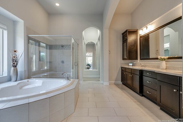 bathroom featuring tile patterned flooring, vanity, and separate shower and tub