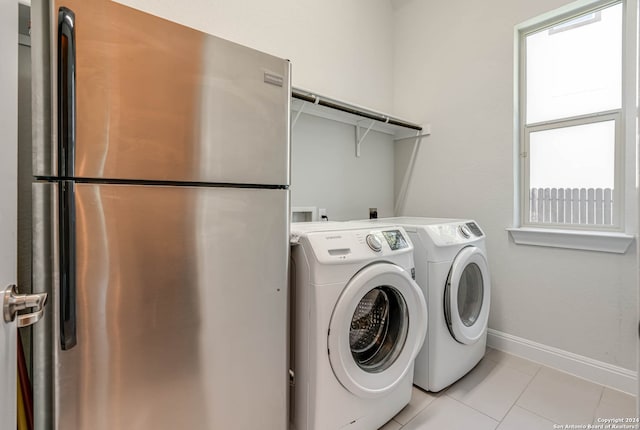 laundry area featuring washer and clothes dryer, a healthy amount of sunlight, and light tile patterned floors