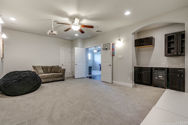 living area with light carpet and beverage cooler