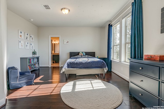 bedroom featuring dark hardwood / wood-style flooring, connected bathroom, and multiple windows