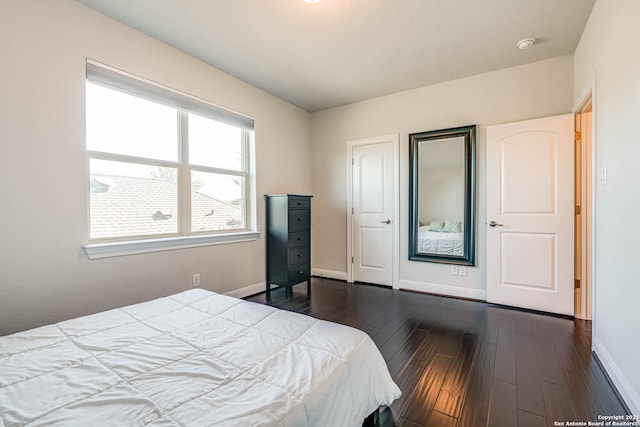 bedroom with dark wood-type flooring