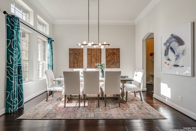 dining area featuring crown molding, dark wood-type flooring, and an inviting chandelier