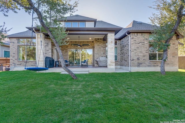 back of property with a patio area, ceiling fan, and a yard