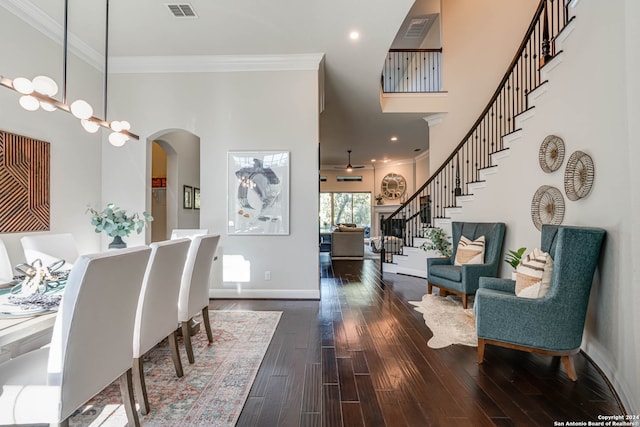 dining room with a high ceiling, dark hardwood / wood-style flooring, ceiling fan, and crown molding