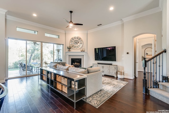 living room with ceiling fan, a fireplace, dark hardwood / wood-style floors, and ornamental molding