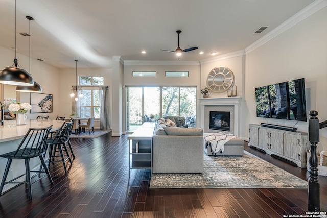 living room with ceiling fan, dark wood-type flooring, and ornamental molding