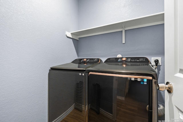 laundry room with independent washer and dryer and dark hardwood / wood-style floors