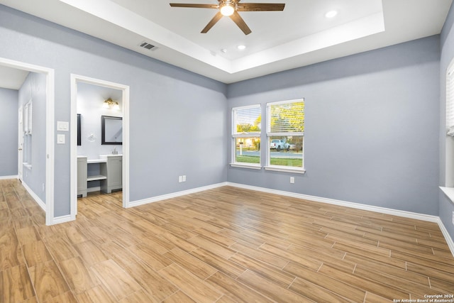 5882 Castle Run, San Antonio, TX 78218 - unfurnished bedroom featuring a tray ceiling, baseboards, light wood-style floors, a ceiling fan, and recessed lighting