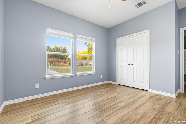 unfurnished bedroom with ceiling fan and a closet