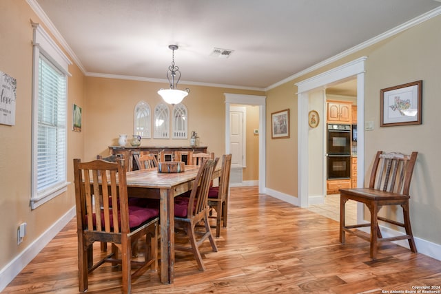 dining area with light hardwood / wood-style flooring and crown molding