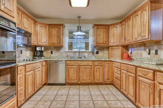 kitchen with light stone counters, hanging light fixtures, backsplash, a sink, and black appliances