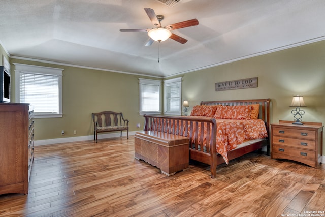 bedroom featuring light hardwood / wood-style floors, multiple windows, ornamental molding, and ceiling fan