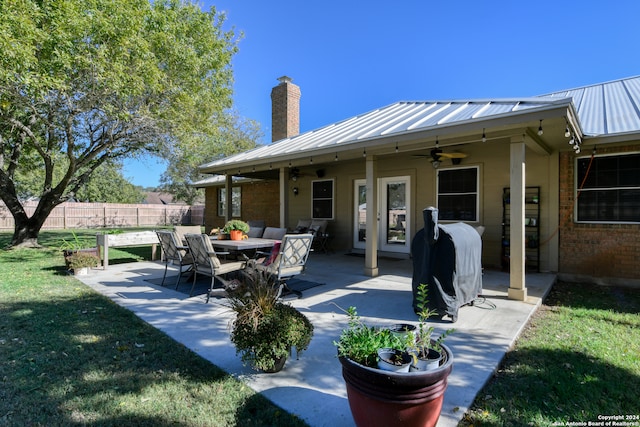 rear view of house featuring ceiling fan, a yard, and a patio