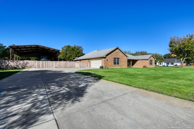 view of front of house with brick siding, concrete driveway, an attached garage, a front yard, and fence