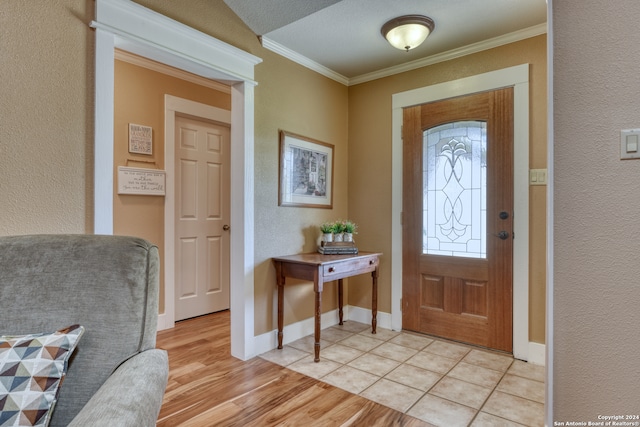 foyer entrance featuring a textured ceiling, light hardwood / wood-style floors, and crown molding