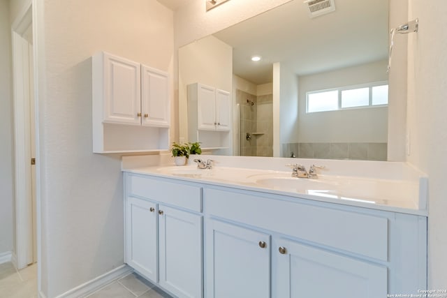 bathroom with tile patterned floors, vanity, and tiled shower