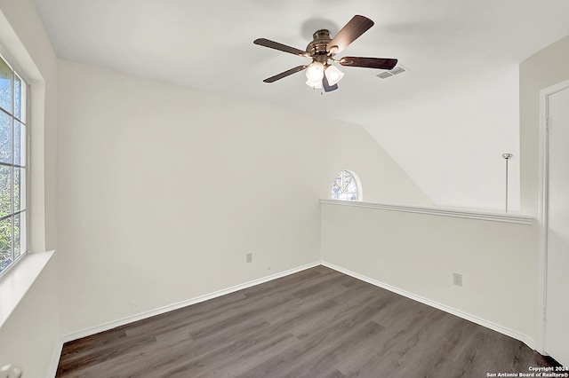 spare room with a wealth of natural light, ceiling fan, dark wood-type flooring, and lofted ceiling