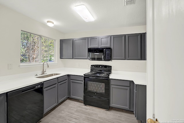 kitchen featuring light hardwood / wood-style floors, a textured ceiling, sink, black appliances, and gray cabinets