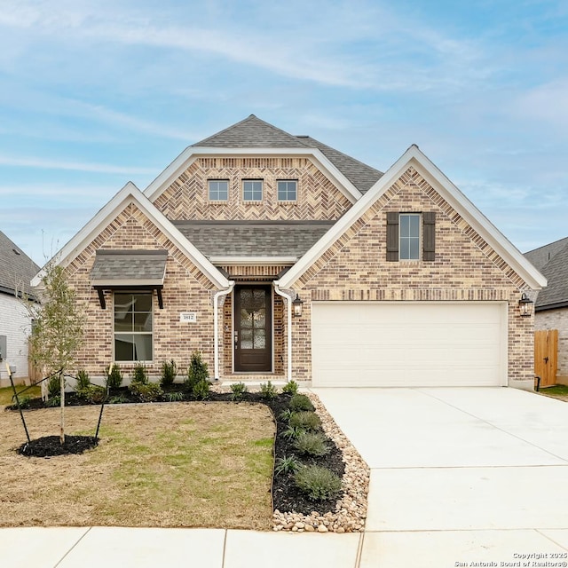 view of front of property featuring driveway, a garage, a shingled roof, a front lawn, and brick siding