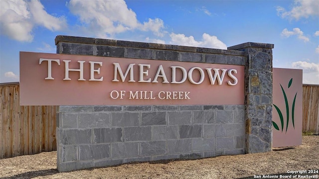 community sign featuring fence