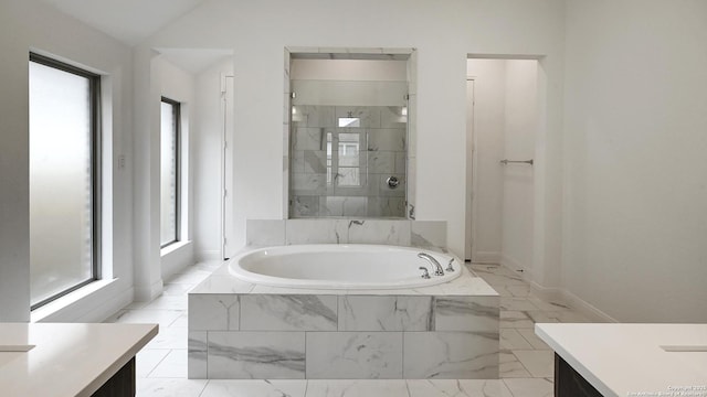 bathroom with lofted ceiling, a stall shower, a garden tub, and vanity