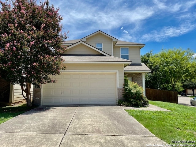 view of front of property featuring a garage and a front lawn