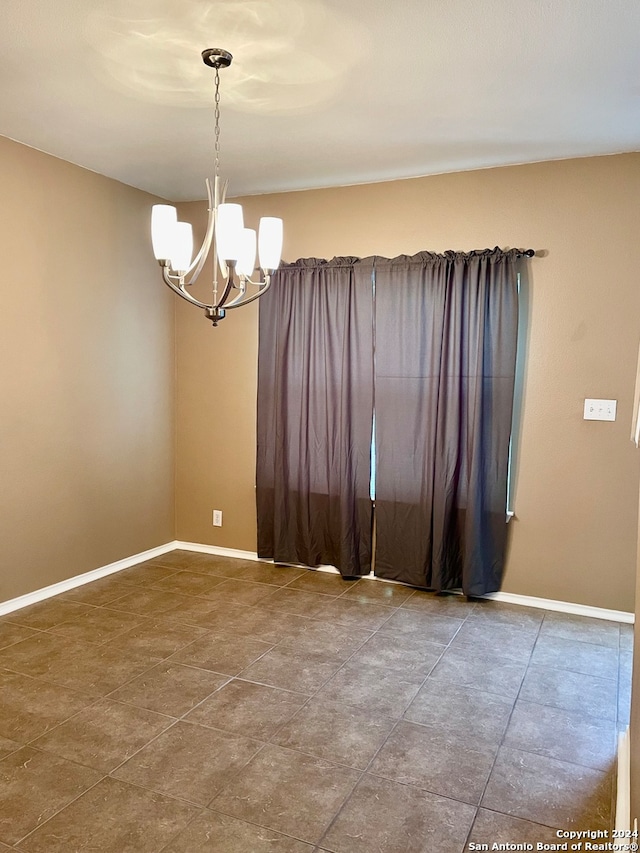 unfurnished room featuring a notable chandelier