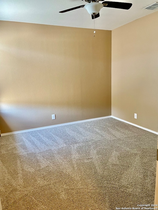 carpeted spare room with ceiling fan