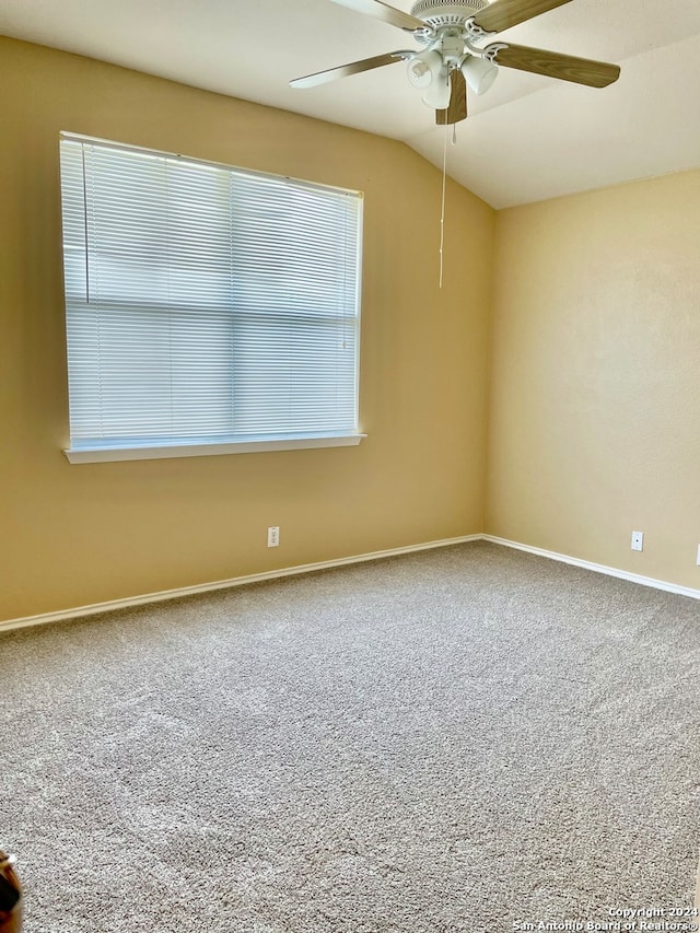 empty room featuring ceiling fan, carpet floors, and vaulted ceiling