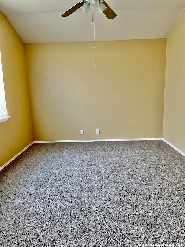 unfurnished room featuring ceiling fan and carpet