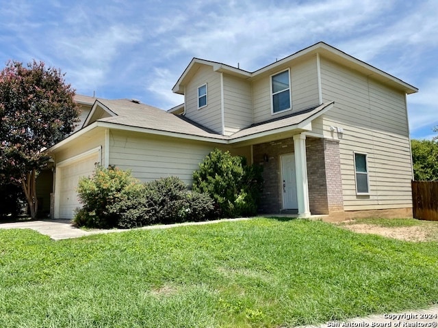 view of front of property featuring a garage and a front lawn