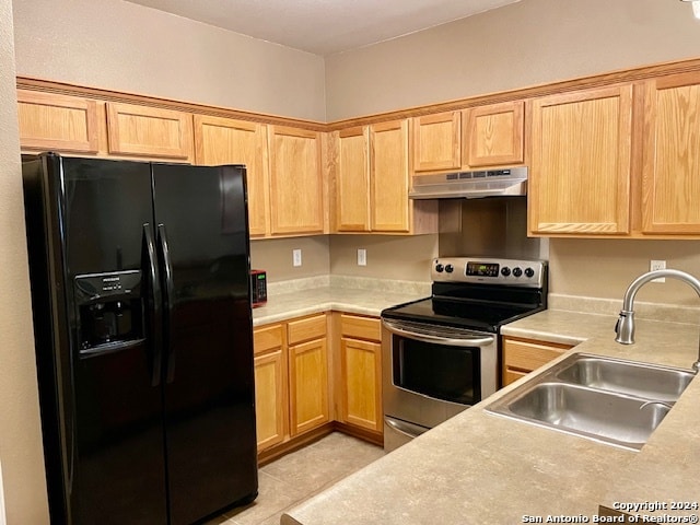 kitchen featuring stainless steel electric range oven, black fridge with ice dispenser, light tile patterned floors, and sink