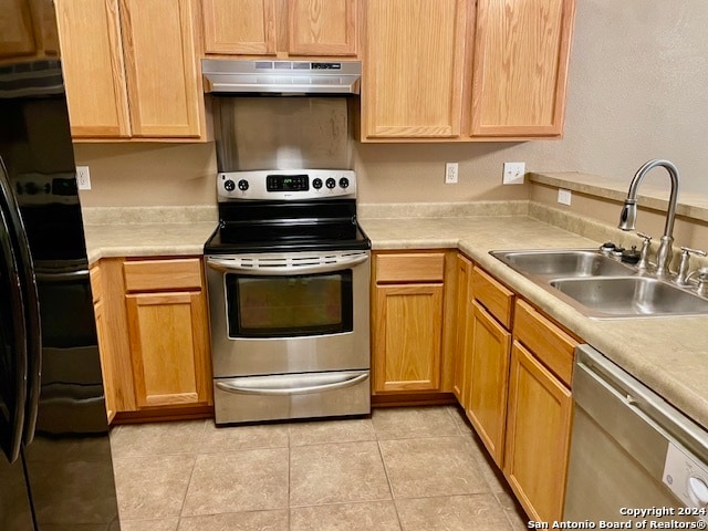 kitchen with sink, light tile patterned floors, and stainless steel appliances