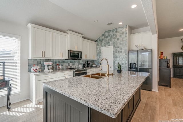 kitchen featuring a kitchen island with sink, white cabinets, and stainless steel appliances