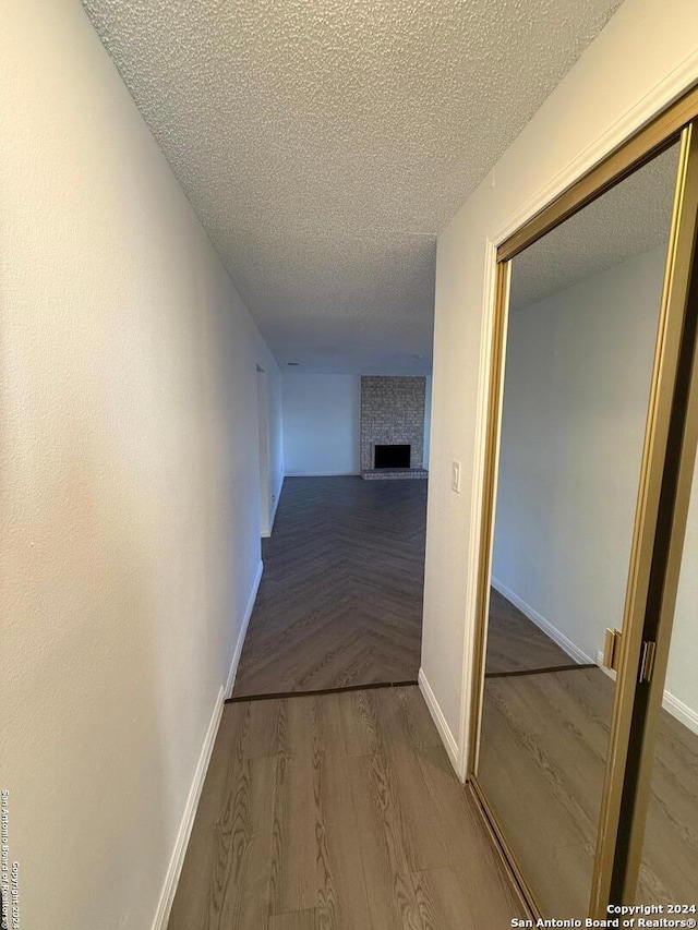 hallway featuring a textured ceiling and hardwood / wood-style flooring