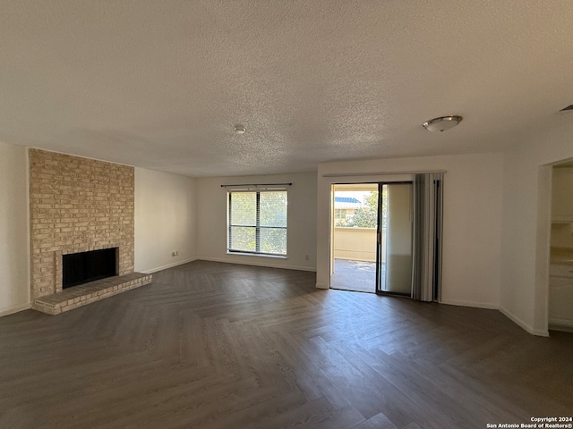 unfurnished living room with a fireplace, dark parquet floors, and a textured ceiling