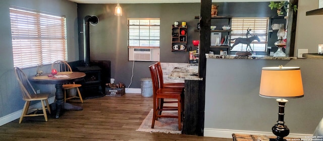 bar featuring cooling unit, light stone countertops, a wood stove, and dark wood-type flooring