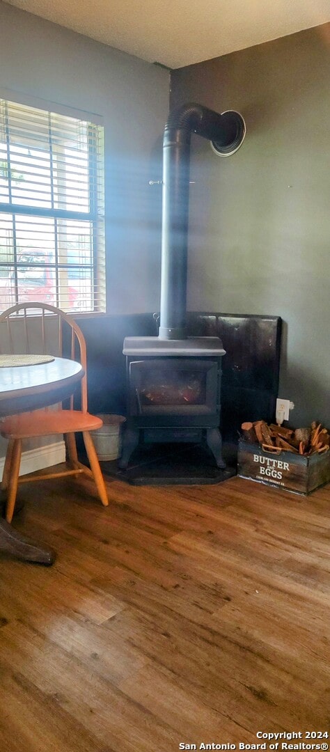 interior details featuring hardwood / wood-style floors and a wood stove