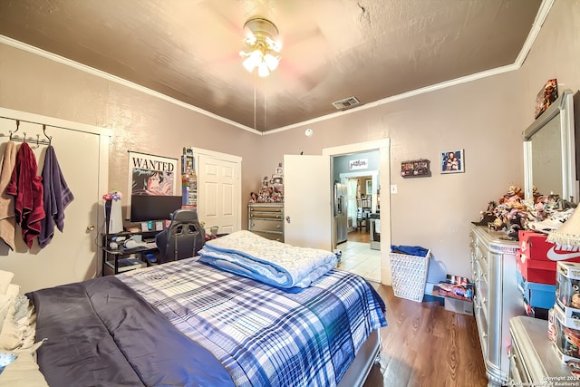 bedroom with ornamental molding, wood-type flooring, stainless steel fridge with ice dispenser, a closet, and lofted ceiling