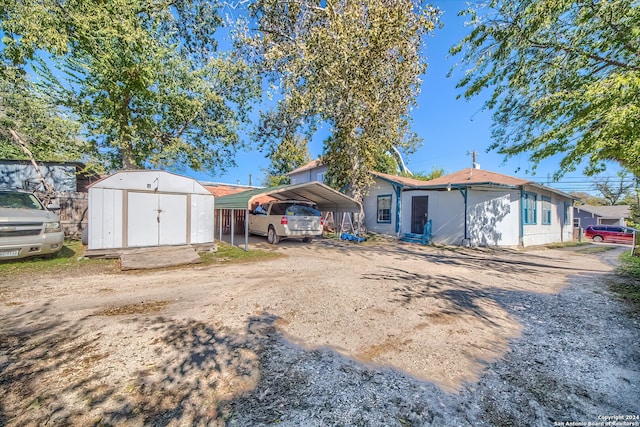 rear view of house featuring a storage unit and a carport