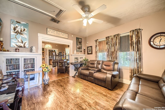 living room featuring ceiling fan, wood-type flooring, a fireplace, and french doors