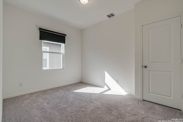 spare room featuring light colored carpet