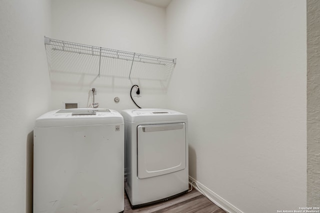 washroom with separate washer and dryer and hardwood / wood-style flooring