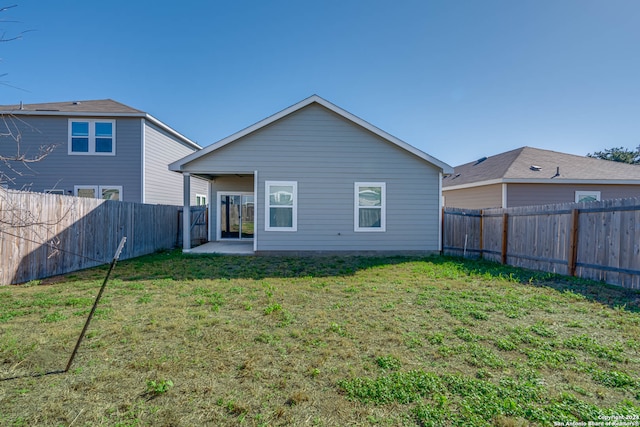 rear view of property featuring a yard and a patio area