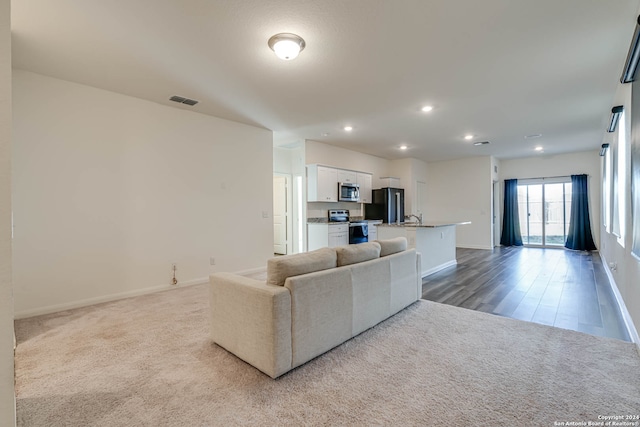 unfurnished living room with light hardwood / wood-style floors and sink