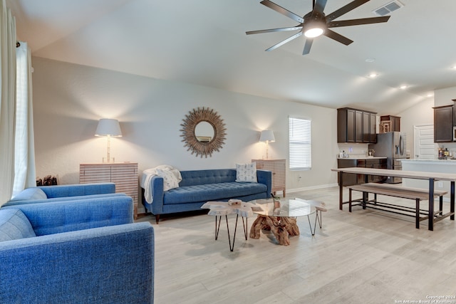 living room with ceiling fan, light hardwood / wood-style floors, and lofted ceiling